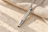 Silver-tone Stillflow breathing necklace on pale stone with natural linen.