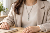 Stillflow silver-tone breathing necklace worn over an ivory knit during a quiet desk pause.