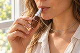 An adult holding the walnut Woodland Pause pendant to its mouthpiece in natural daylight.